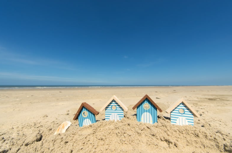 Small houses buried in sand on a beach