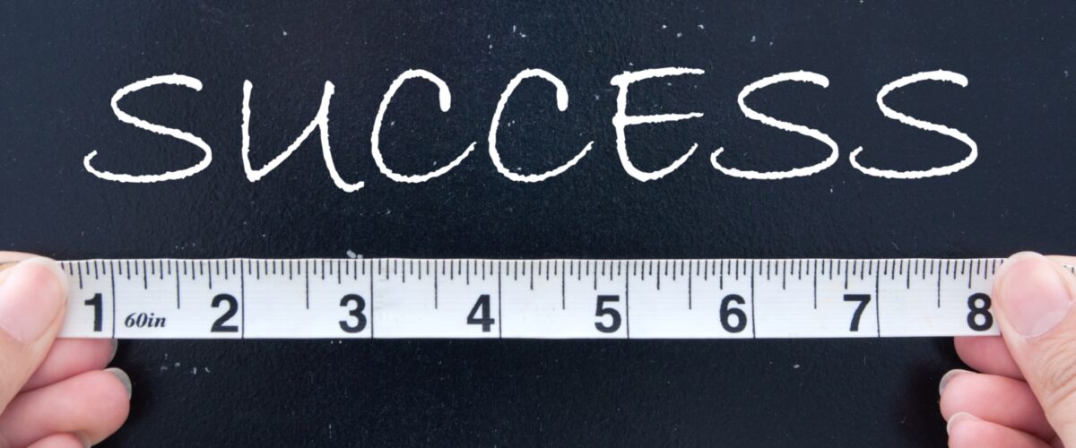 An image of a tape measure and the word success - illustrating measurable impact in B2B communications