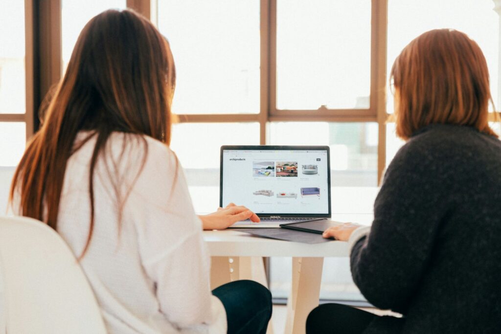 HR trends in April 2026: An image of two women sat around a laptop