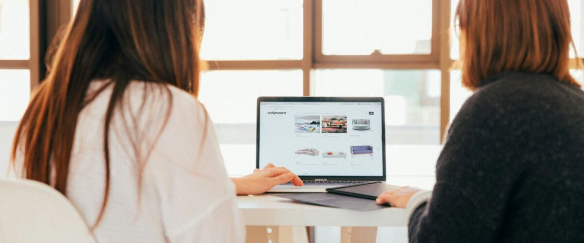 HR trends in April 2026: An image of two women sat around a laptop
