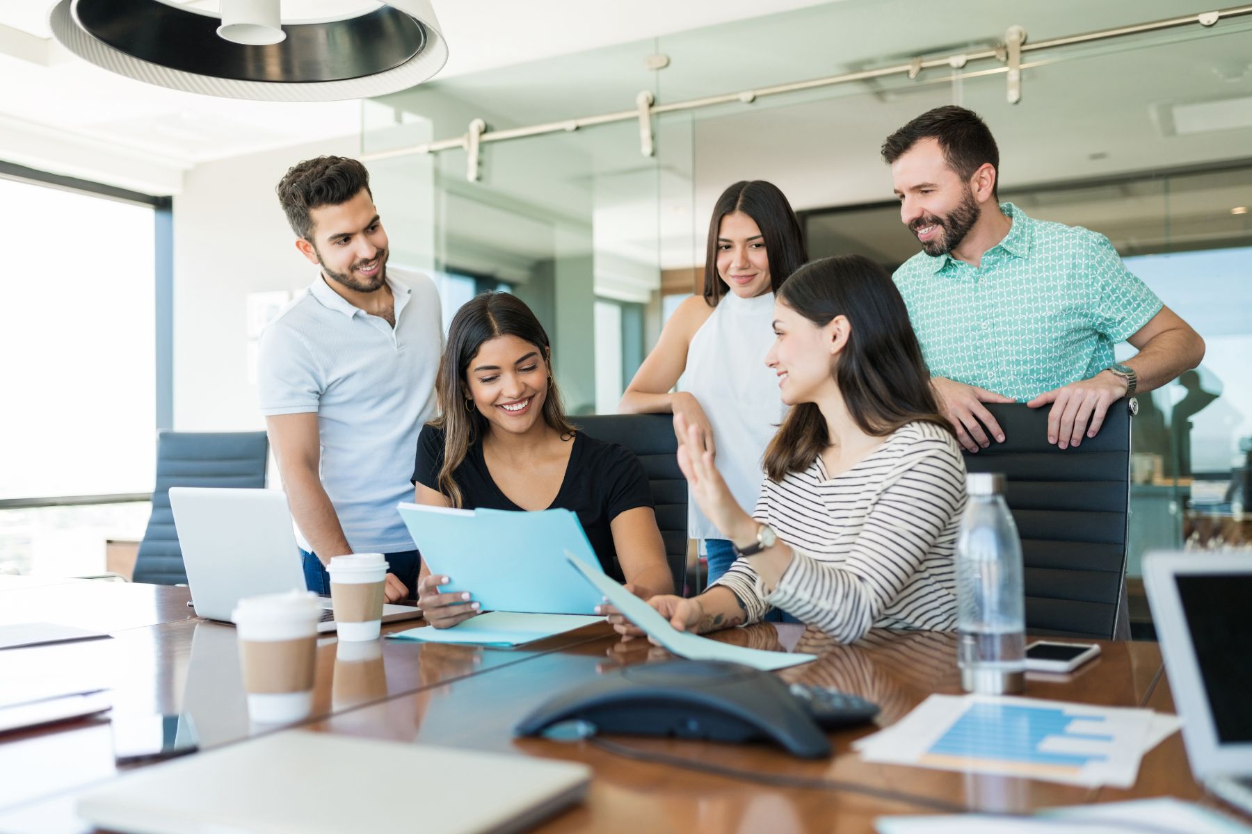 An image of employees gathered around a meeting table: Reflecting the focus of this blog on July's HR marketing insights