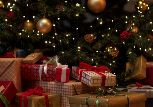 An image of a festive Christmas tree with wrapped presents underneath